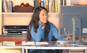 Asian girl looking at a monitor in a home office
